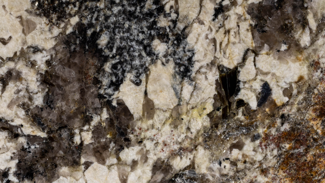 Zbliżenie na strukturę spieku kwarcowego imitującego naturalny granit z wyrazistym, wielobarwnym żyłkowaniem